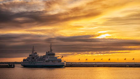 HELSINGBORG, SWEDEN - AUGUST 16, 2019: Hamlet the passanger and freight ferry sails into Helsingborg harbour in Sweden at sunset.のeditorial素材