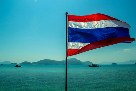 National flag of Thailand closeup against the sea. Beautiful seascape with a ships in the gulf. Thai symbol on the background  of the blue horizon.の写真素材