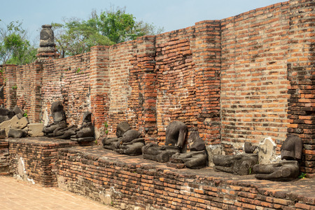 Ruins of Wat Mahathat temple with ancient broken headless Buddha statues in Ayutthaya historical park, Thailandの写真素材