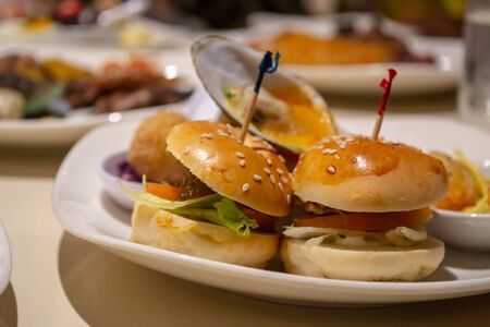 Plate with mini burgers and other delicious appetizier for dinner at the hotel restaurantの写真素材