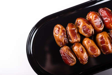 Close up of Dates fruit in a black elegant plateの写真素材