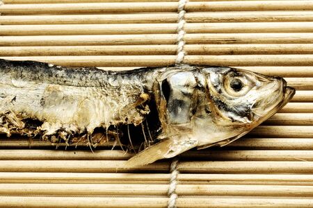 Dried fish on wooden Japanese place matの写真素材