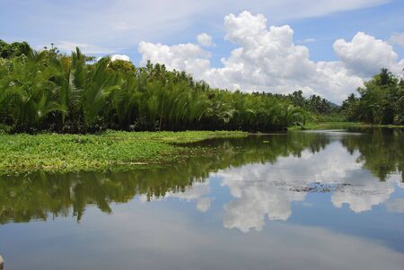 Sky and clouds reflected on a river in Tacloban, Philippinesの写真素材