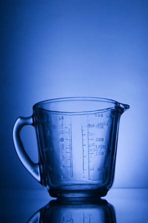 Measuring cup against blue background lightの写真素材