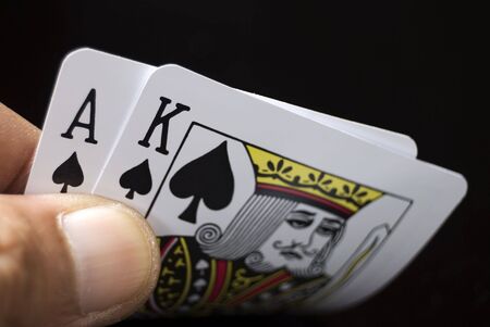Blackjack cards held by hand against black backgroundのeditorial素材
