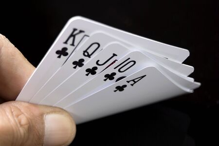Royal Flush held by hand against black backgroundの写真素材