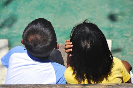 Kids watching game in basketball court, back towards cameraの写真素材
