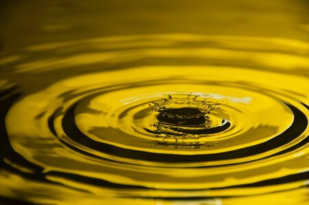 Close-up of water droplet reflected on yellow backgroundの写真素材