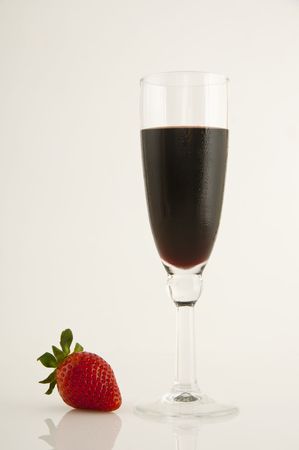 Close-up of bright red strawberry beside glass of red wineの写真素材