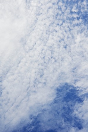 Fluffy white clouds shot from belowの写真素材