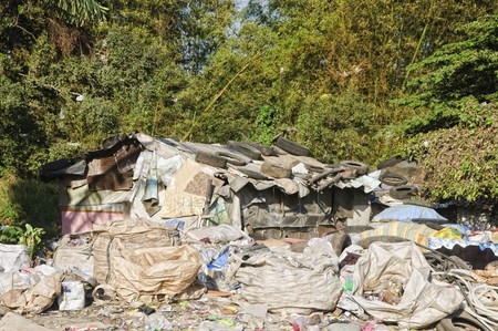 Sacks and sacks of garbage in front of a shantyの写真素材