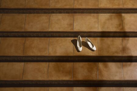 Wedding shoes on bridal gown surrounded with flowersの写真素材