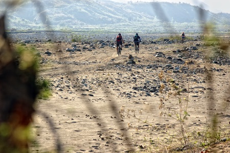 QUIRINO, PHILIPPINES - MARCH 31: Unidentified mountain bikers cross a dry river on March 31, 2007 in Quirino, Philippines during a のeditorial素材