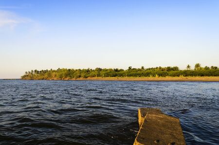Part of a damaged jetty overlooking an islandの写真素材