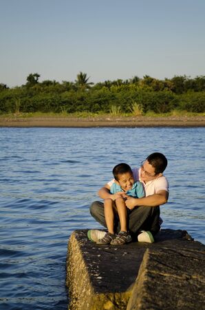 Father and son on a jetty during a bonding moment の写真素材