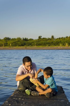 Father and son on a jetty during a bonding moment の写真素材
