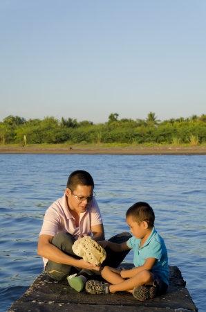 Father and son on a jetty during a bonding moment の写真素材