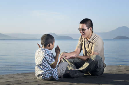 Father and son on a jetty during a bonding moment の写真素材