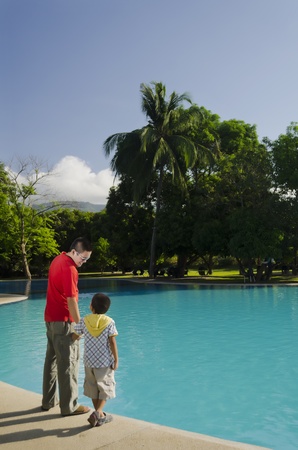 Father and son by the pool during a bonding moment の写真素材
