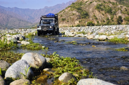 A Land Rover Defender crosses a long, dry river in the province of Quirino, Philippinesのeditorial素材