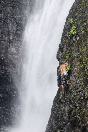 Man attempts to climb natural waterfall in a tropical forest in the Philippinesのeditorial素材