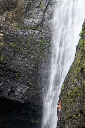 Man attempts to climb natural waterfall in a tropical forest in the Philippinesのeditorial素材