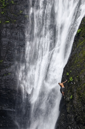 Man attempts to climb natural waterfall in a tropical forest in the Philippinesのeditorial素材