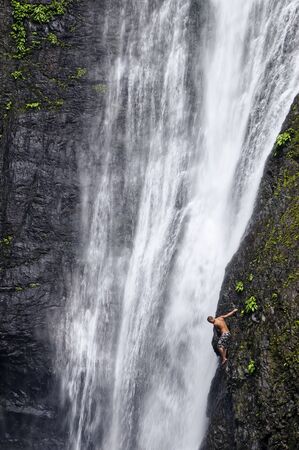 Man attempts to climb natural waterfall in a tropical forest in the Philippinesのeditorial素材