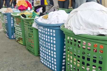 A line of laundry baskets full of dirty clothes for washingの写真素材