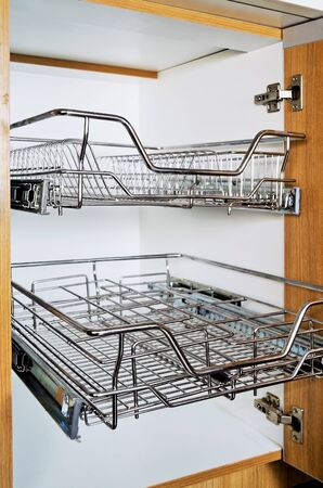 Open kitchen cabinet with two layers of stainless dish rackの写真素材