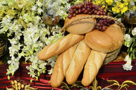 Bread, flowers, and grapes still life on red clothの写真素材