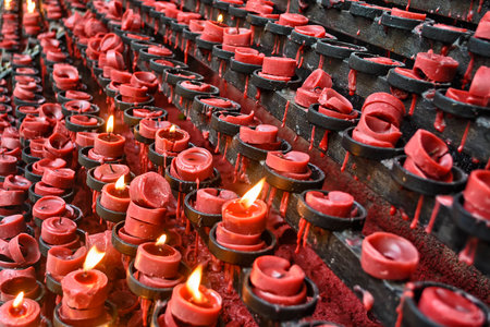 Lit and unlit red little candle offerings of people for their loved onesの写真素材