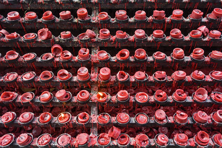 Lit and unlit red little candle offerings of people for their loved onesの写真素材