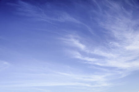 Wispy, thin cirrus clouds against blue skyの写真素材