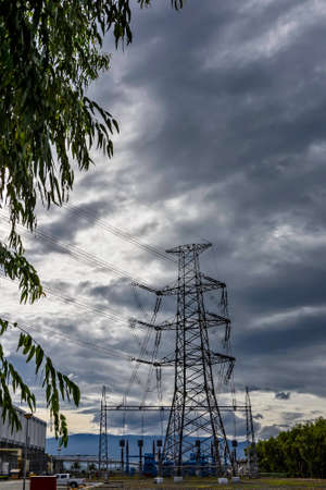 Power plant transmission line against dark ominous cloudsの写真素材
