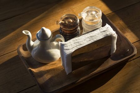 Vinegar, soy sauce, salt and napkin on wooden tableの写真素材