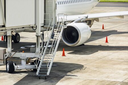 Airport service vehicles standby on airport tarmac with airplaneの写真素材