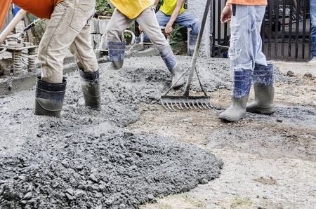 Men levelling newly poured road concrete mixの写真素材