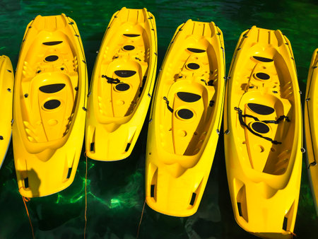 Close-up shot of several bright yellow kayaks floating on the turquoise sea water.の写真素材