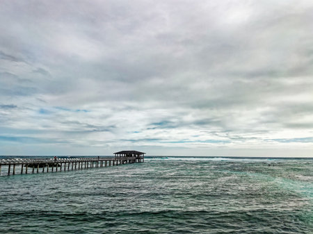 Wooden jetty in the ocean with cloudy sky and copy spaceの写真素材