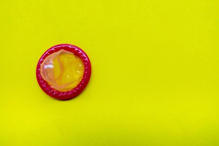 condom on a yellow background. The concept of safe sex.の写真素材