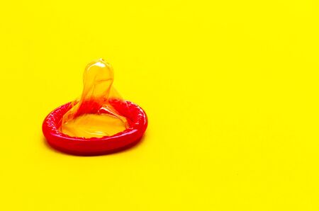 condom on a yellow background. The concept of safe sex.の写真素材