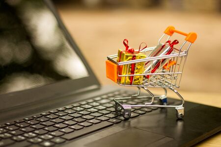 Red heart in a trolley on a laptop keyboard. Ideas about online shopping, online shopping is a form of electronic commerce that allows consumers to directly buy goods from a seller over the internet.の写真素材