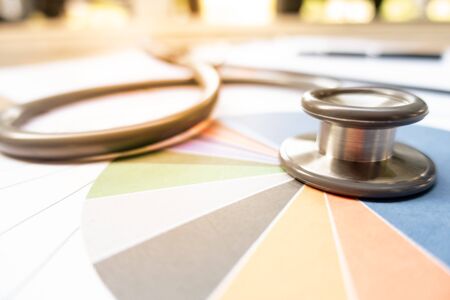 Stethoscope on Charts and Graphs spreadsheet paper , Finance, Account, Statistics, Investment, Analytic research data economy spreadsheet and Business company concept.の写真素材