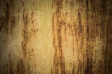Old grungy cracked weathered wall paint peeling off rusted metal sheet. Textured background for...