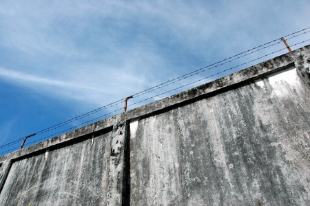 the prison walls with high walls and barbed iron wireの写真素材