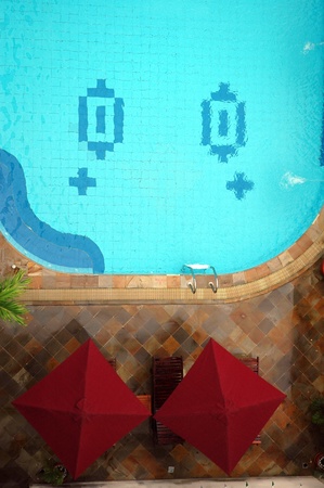 view from the top of beautiful swimming pool with two red tentのeditorial素材