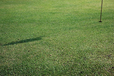 shadow of the flagstick on golf holeの写真素材