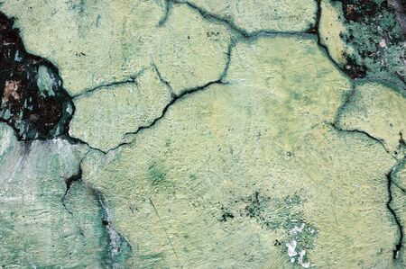cracked walls with paint colors that have faded and mossyの写真素材