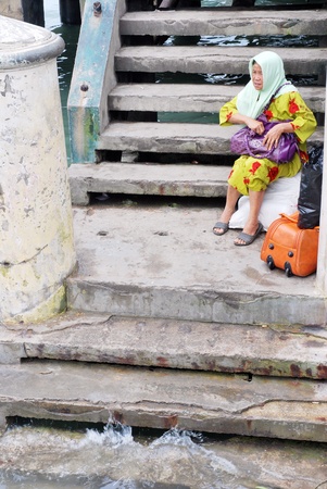 TARAKAN, INDONESIA -  JANUARY 17,  2012 : an elderly woman was waiting at the edge of the dock transport ship on January 17,  2012 at Tarakan city, Indonesiaのeditorial素材